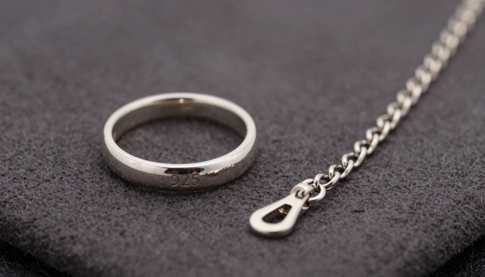 925 sterling silver mark stamped inside a silver ring band next to a necklace clasp